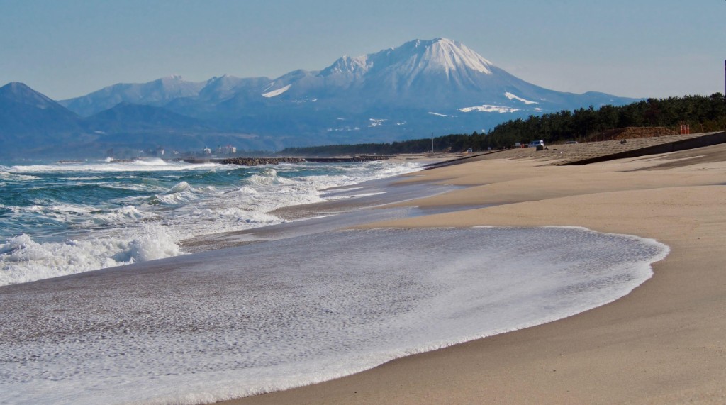 Costa do Mar do Japão na região de Tottori com montanhas nevadas ao fundo — região de San'in onde se desenvolveu a terceira linhagem ancestral do Shiba Inu
