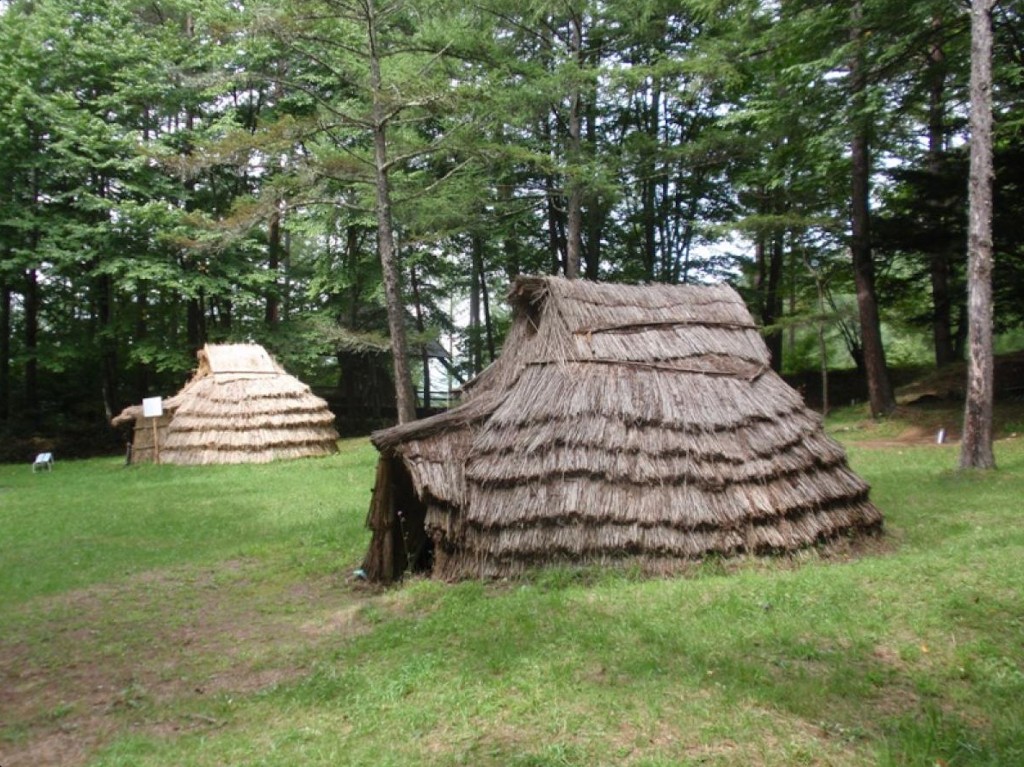 Reconstrução de habitações do período Jōmon com telhados de palha — os Jōmon construíam comunidades estáveis integradas à natureza